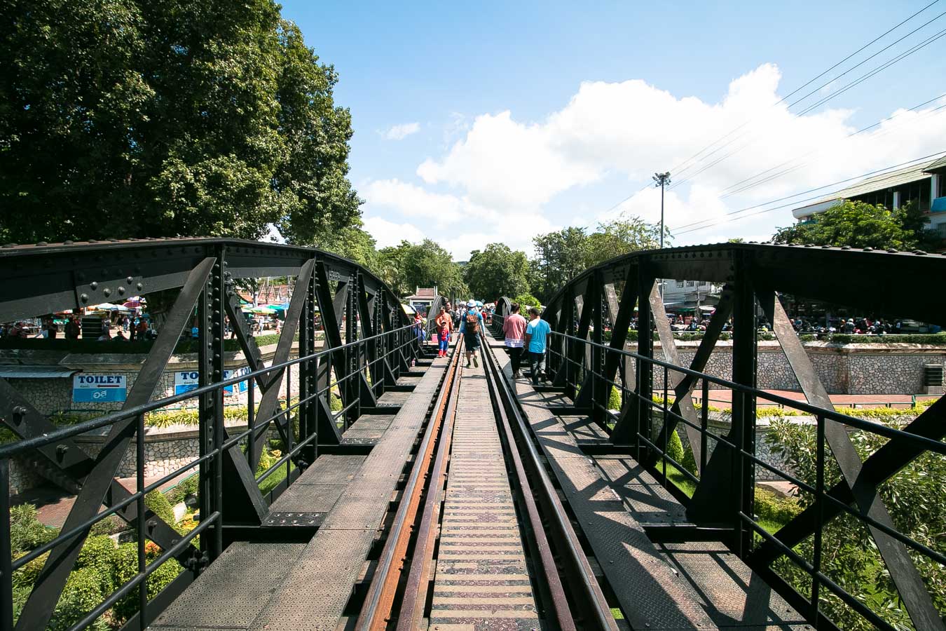 Pessoas caminhando sobre a famosa ponte ferroviária do Rio Kwai em Kanchanaburi.