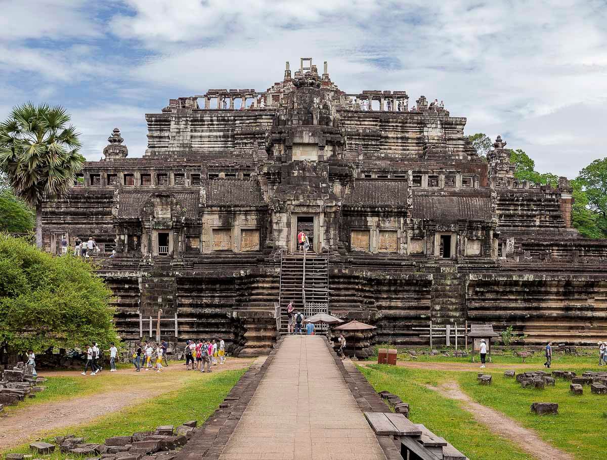 Estrutura em degraus do templo Baphuon, com escadarias e turistas subindo em Siem Reap.
