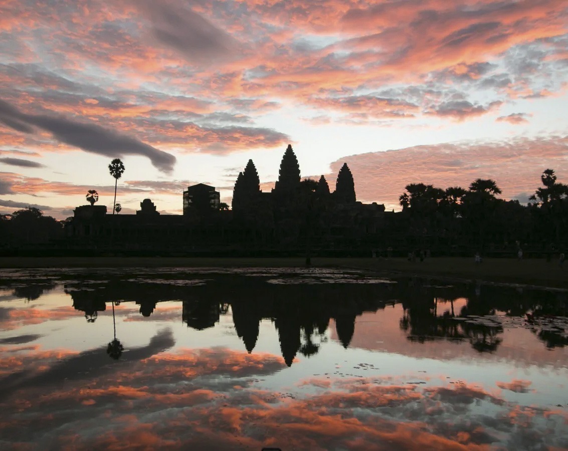 Silhueta de Angkor Wat refletida no lago ao nascer do sol em Siem Reap.