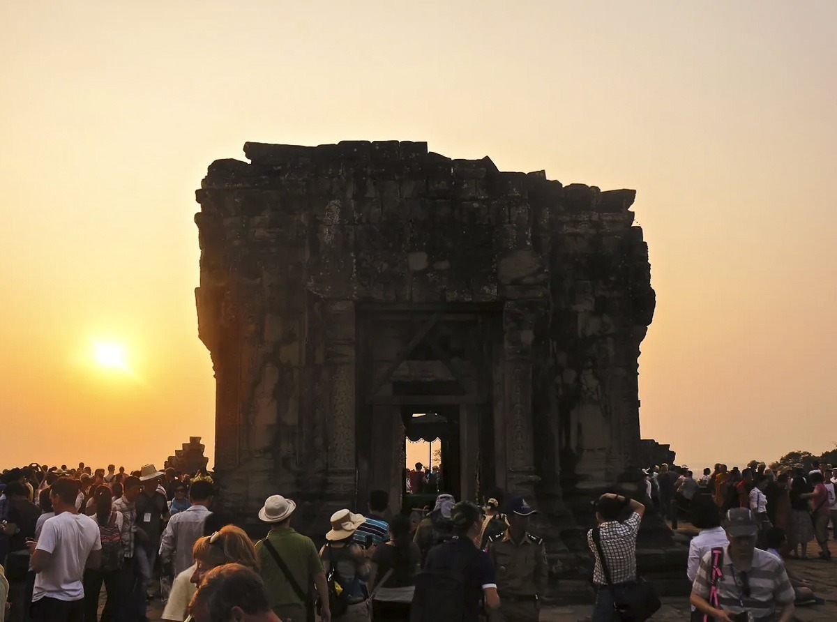 Turistas reunidos no topo do templo Phnom Bakheng para assistir ao pôr do sol em Siem Reap.