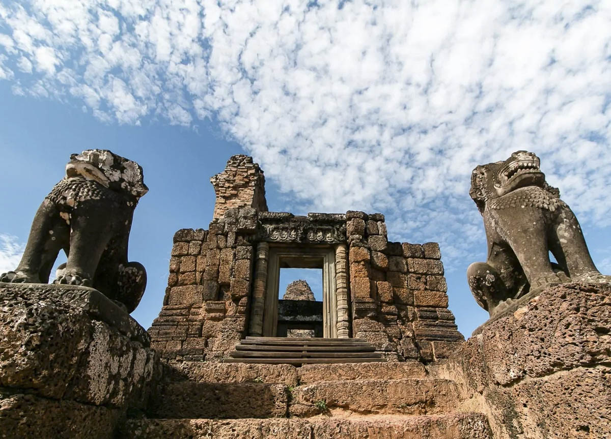 Escadaria de pedra do templo Pre Rup com esculturas de leões e céu azul ao fundo.