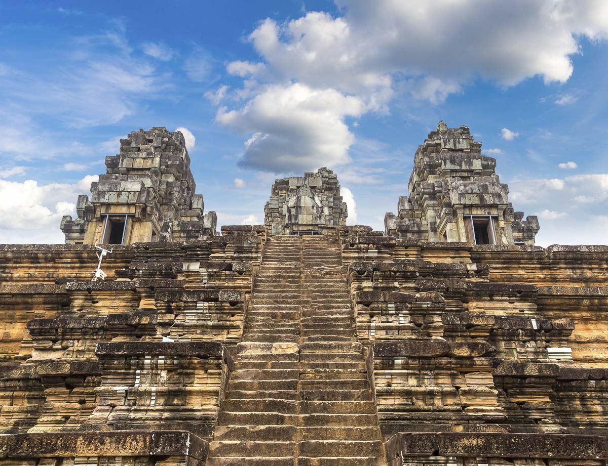 Escadaria íngreme do templo Ta Keo levando a torres de pedra sob o céu azul.