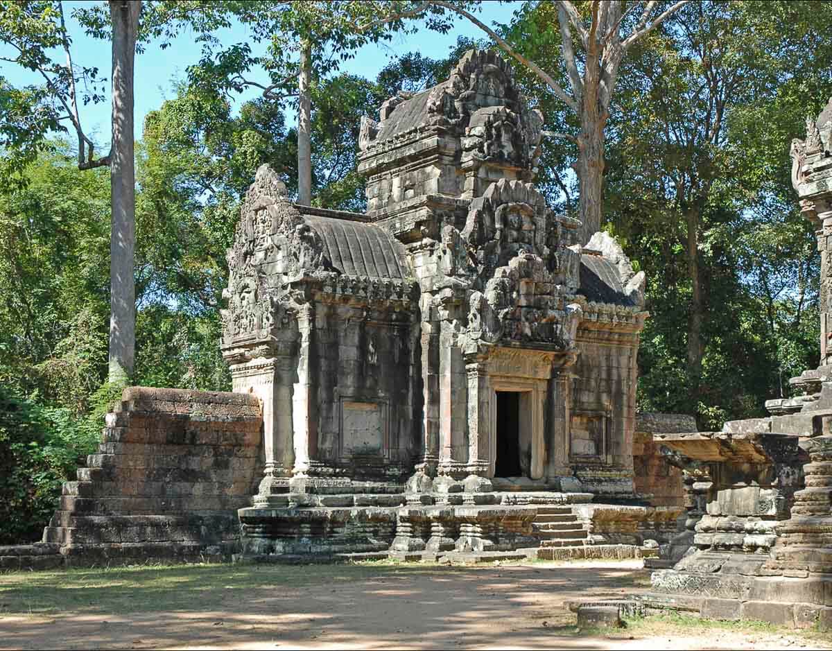Pequeno templo Thommanon com esculturas detalhadas e vegetação ao redor.