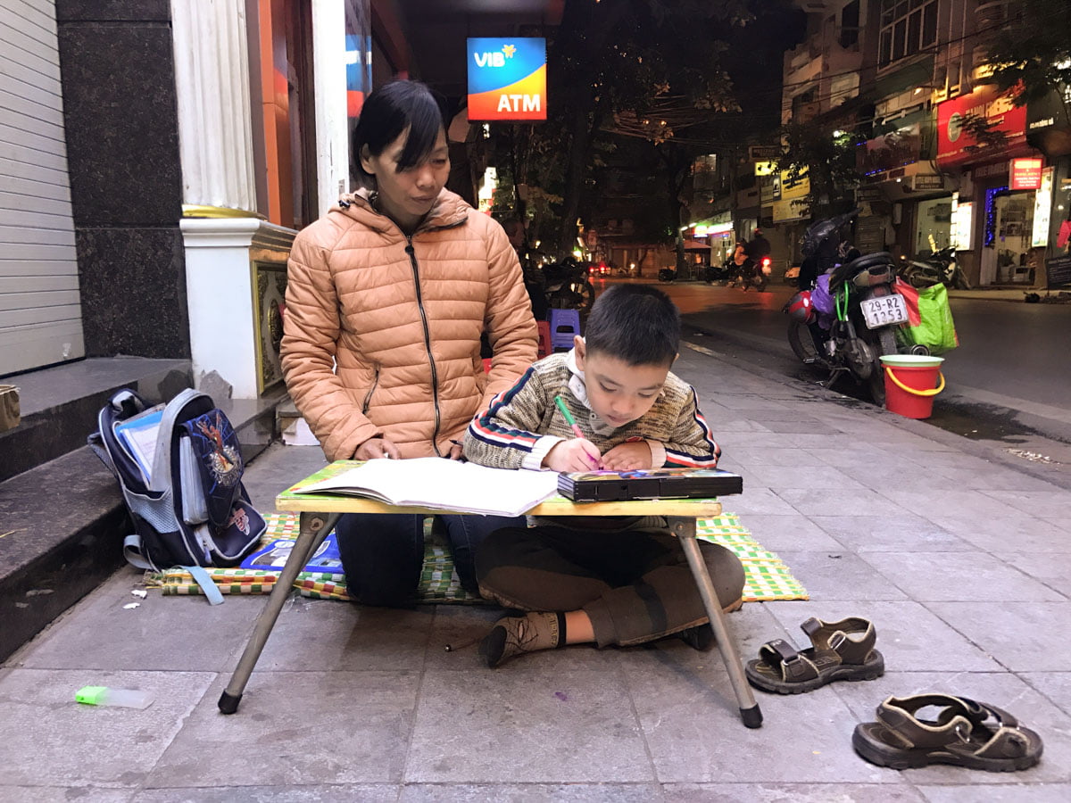 Hanoi - Vietna - Criança fazendo dever de casa sentada na rua
