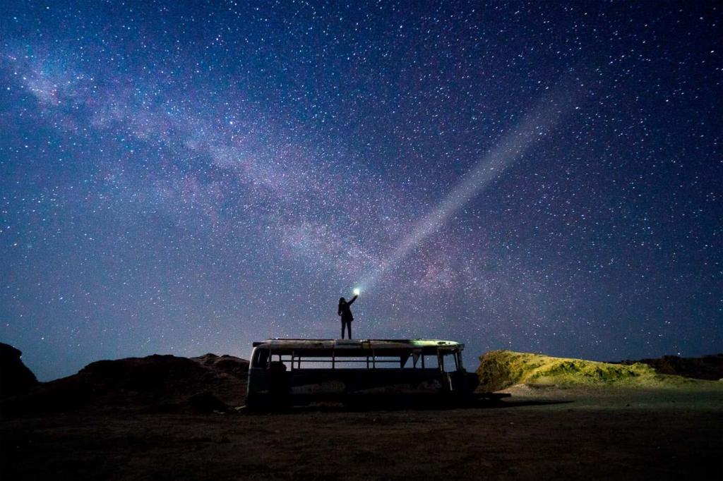 Fotografia da Adriana no tour astronomico em cima do onibus abandonado no Deserto do Atacama com a via Lactea ao fundo