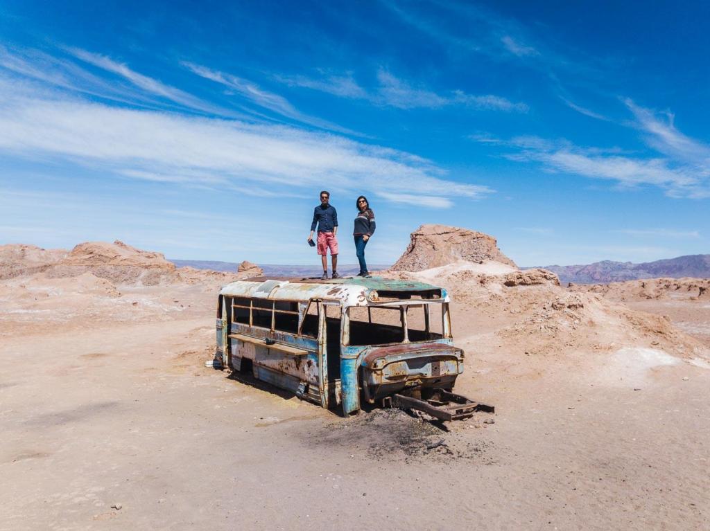 Deserto do Atacama Chile - imagem do ônibus abandonado no meio do deserto do Atacama com Caio e Adriana em pé em cima