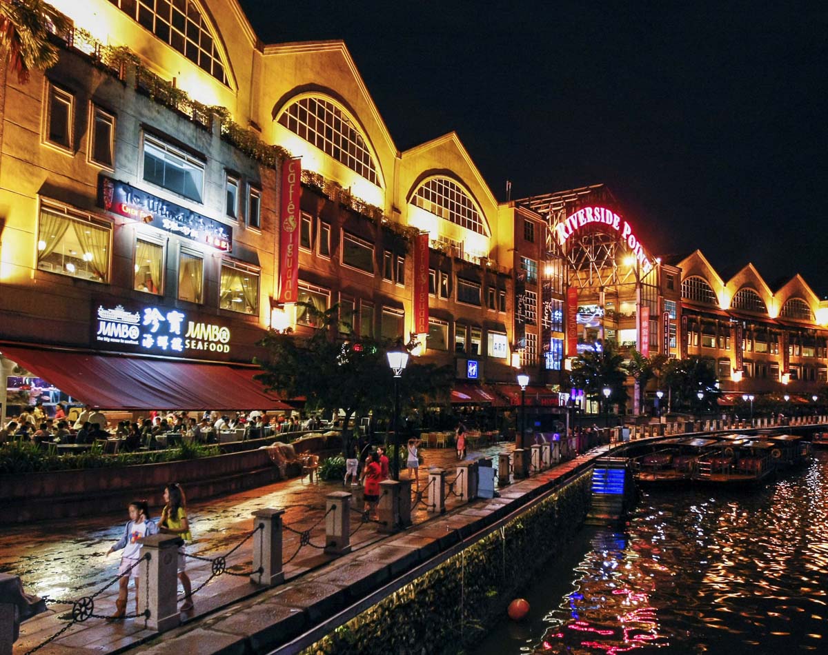 Restaurantes iluminados à beira do rio em Clarke Quay, Singapura.