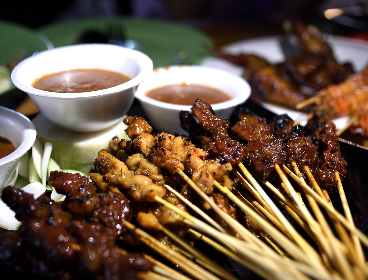 Espetinhos de carne e frango grelhados servidos com molho de amendoim em Singapura.