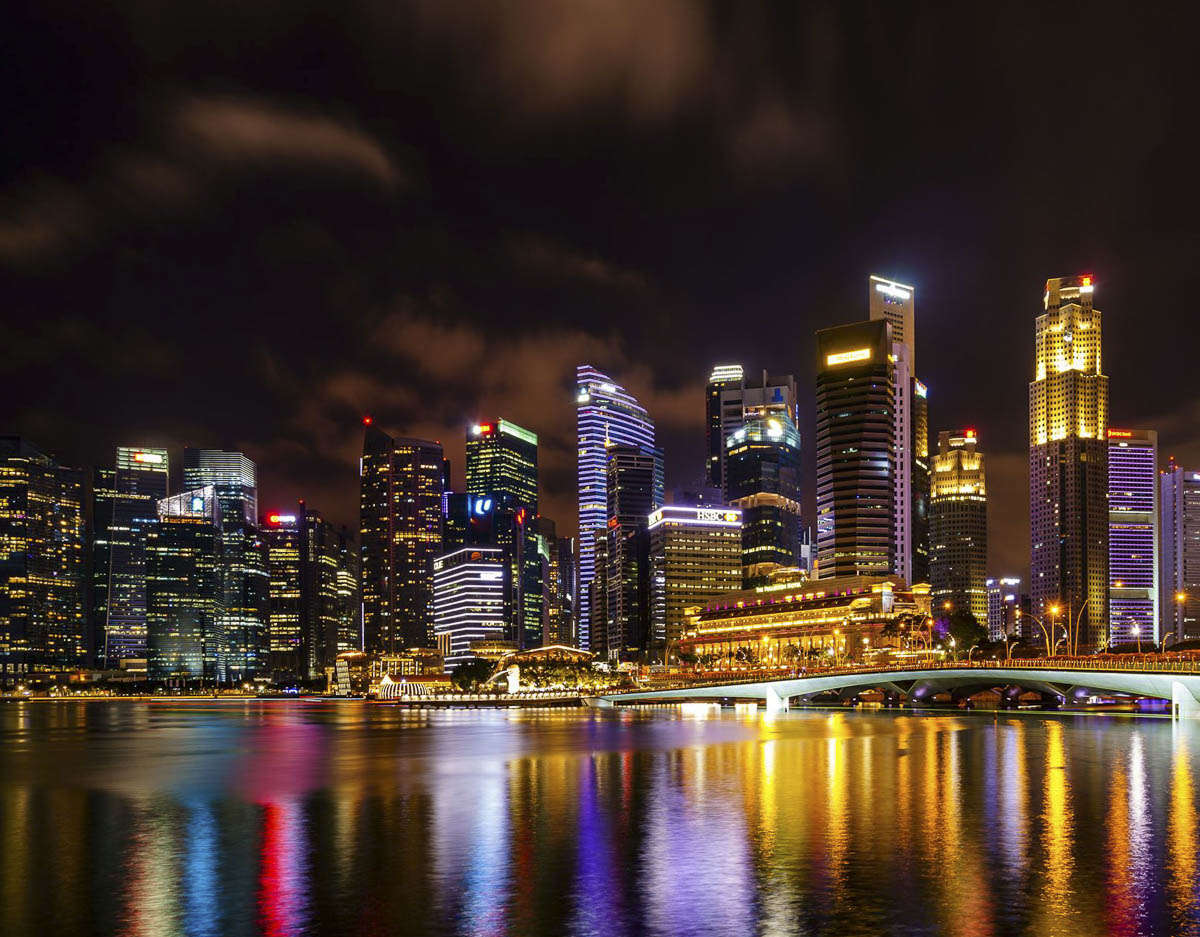 Skyline de Singapura refletido na água durante a noite.