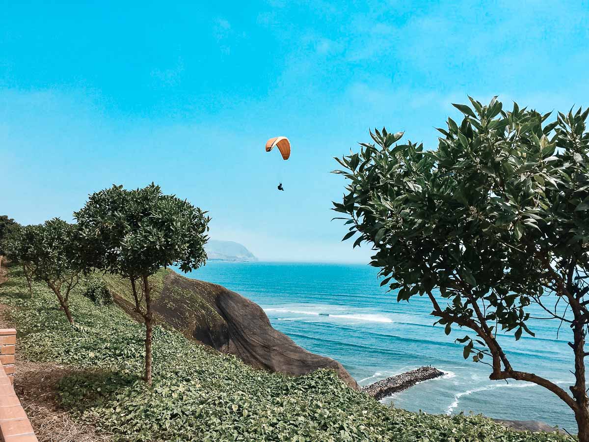 Uma pessoa voando de parapente na área de Miraflores.
