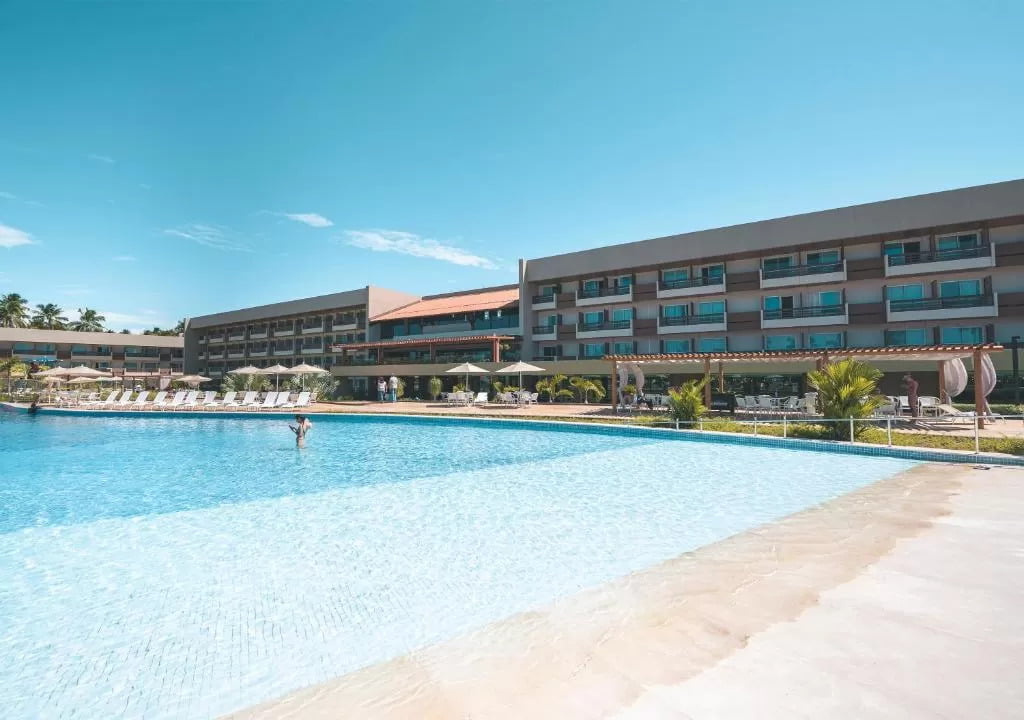 piscina com hotel ao fundo no Japaratinga Lounge Resort 