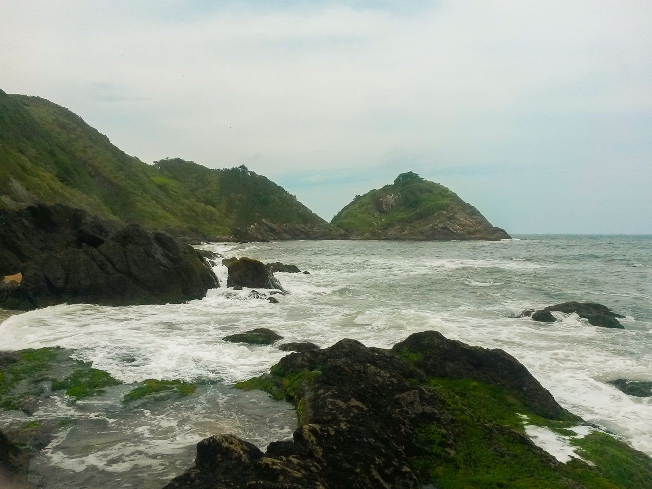 Praia de São Roque cercada por pedras e mar bravio