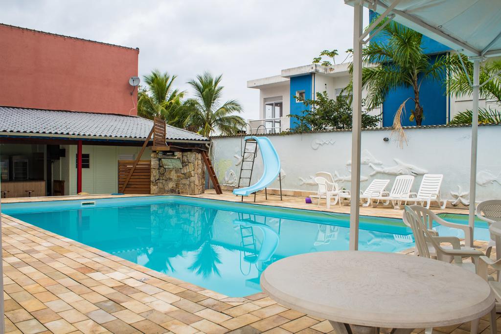 Piscina ao ar livre com mesas e espreguiçadeiras