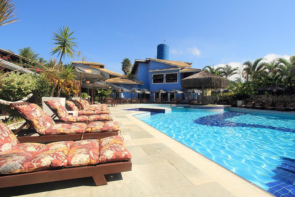 Piscina ao ar livre com espreguiçadeiras acolchoadas