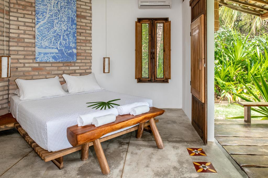 Quarto rústico e elegante com cama de casal e vista para natureza em São Miguel dos Milagres