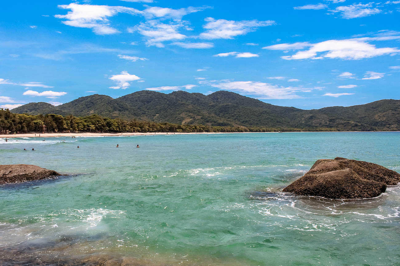 Águas azuis cristalinas e montanhas ao horizonte na Praia de Lopes Mendes