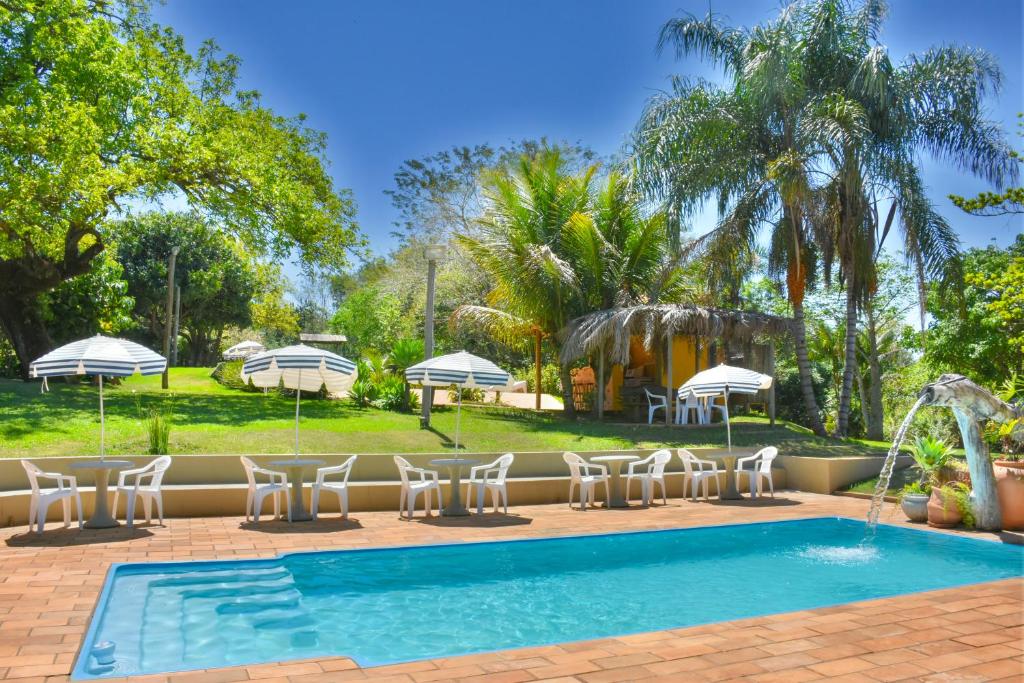 Piscina ao ar livre cercada por jardim e árvores