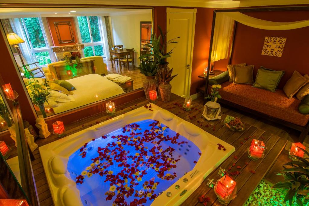 Quarto de casal rústico com banheira e decoração romântica em Gramado