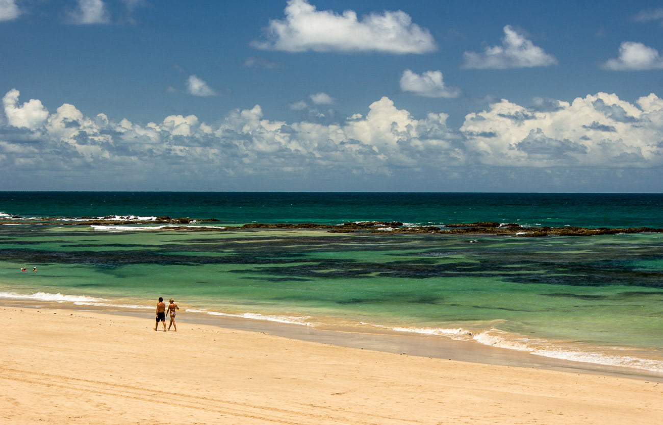 Águas azuis da Praia da Cupe, aparecendo os corais de recife