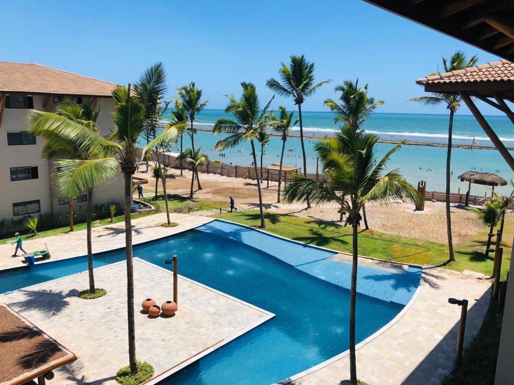 Piscina ao ar livre de resort com vista para a praia em Porto de Galinhas 