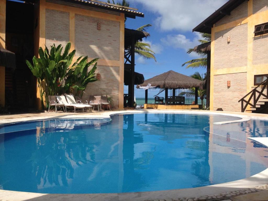 Piscina ao ar livre e ao fundo vista do mar em pousada em Porto de Galinhas 
