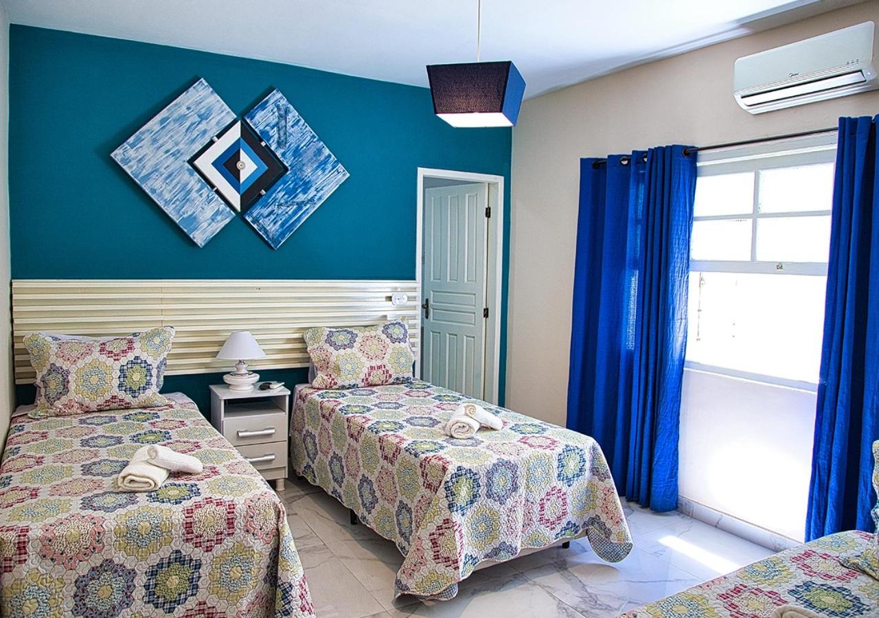 Quarto com duas camas de solteiro e decoração em tons de azuis