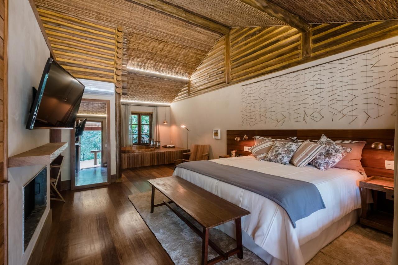Quarto amplo de casal com decoração rústica e sofisticada em pousada em Itaipava