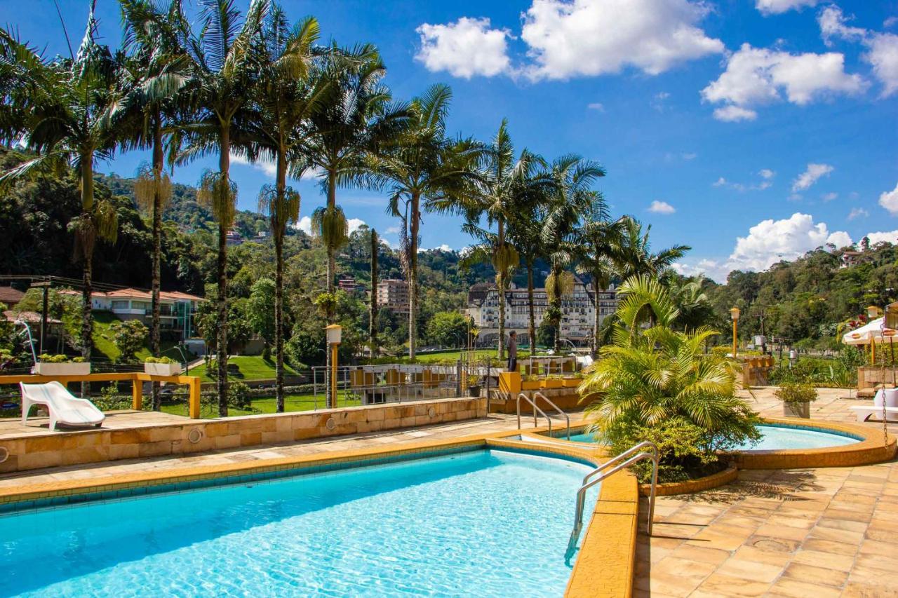 Piscina ao a r livre em região de natureza cercada por coqueiros