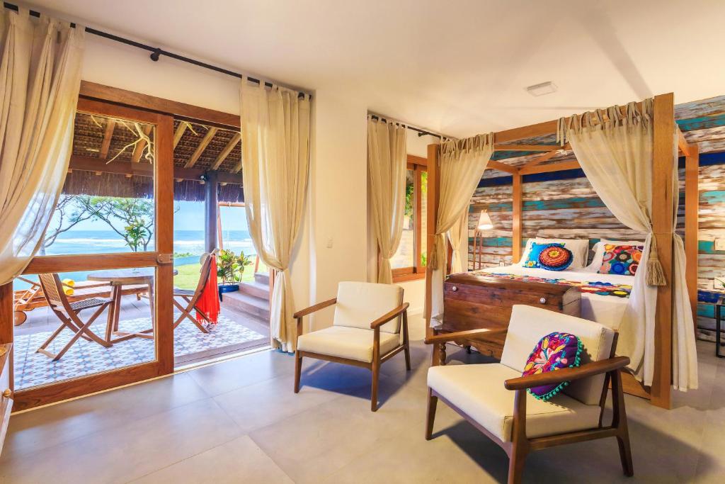 Quarto de casal com decoração rústica elegante e sacada com vista para o mar em resort em Porto de Galinhas