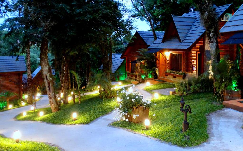 Chalés de madeira com jardins na frente e árvore