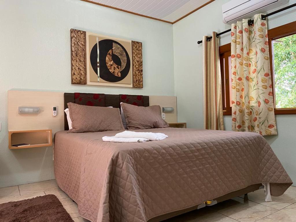 Quarto de casal com decoração simples em pousada chalé em Gramado