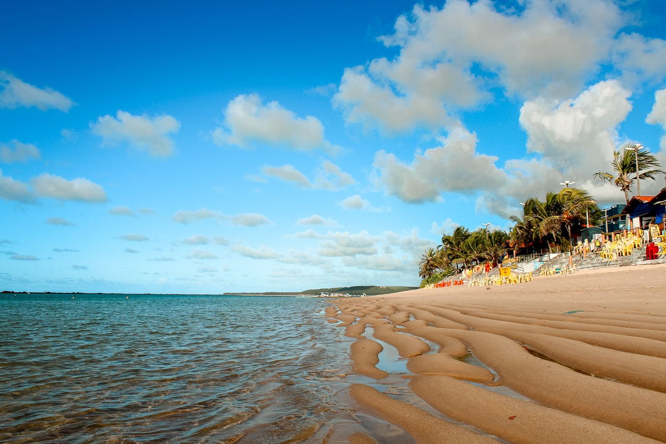 Praia de São Miguel da Barra com mesas e cadeiras na areia