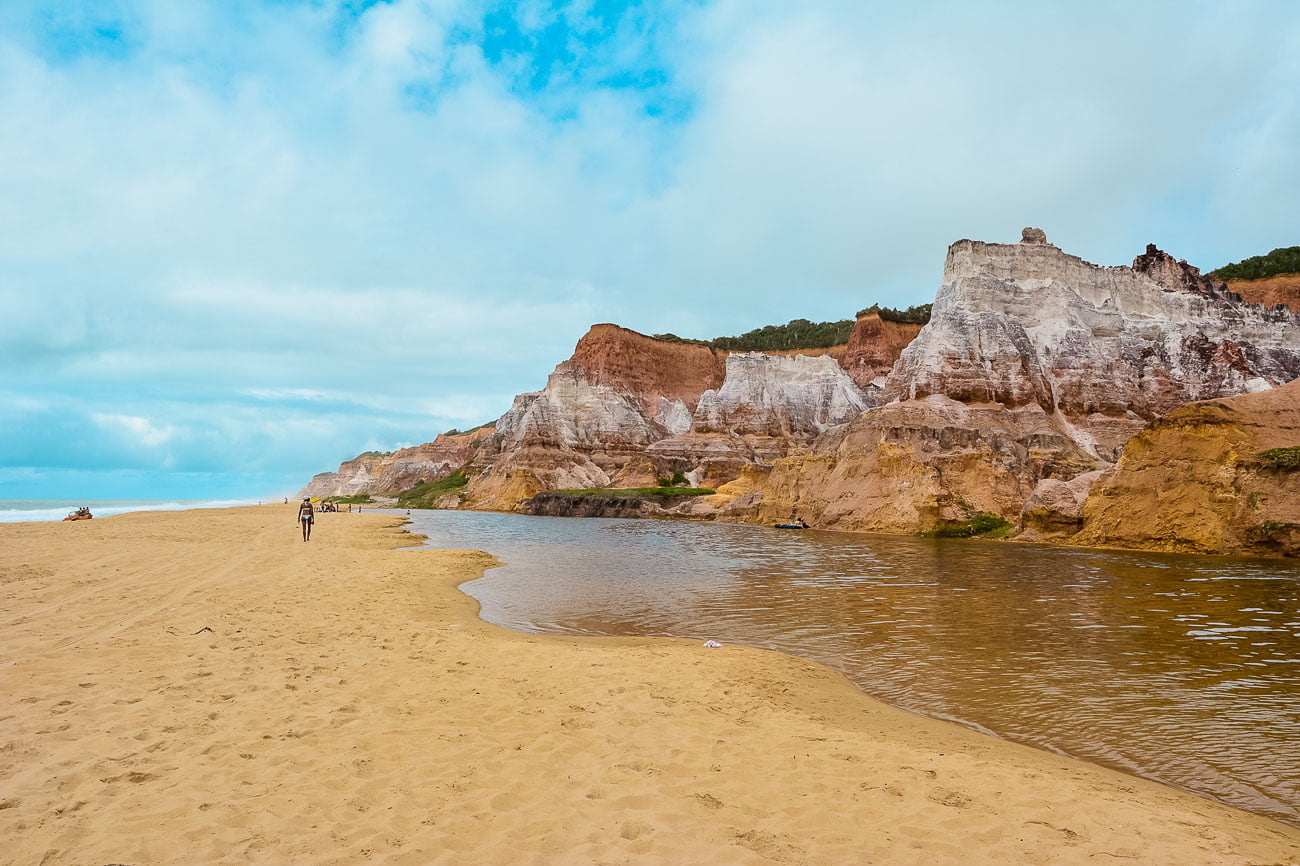 A Praia do Gunga com o rio e falésias em um dia de sol