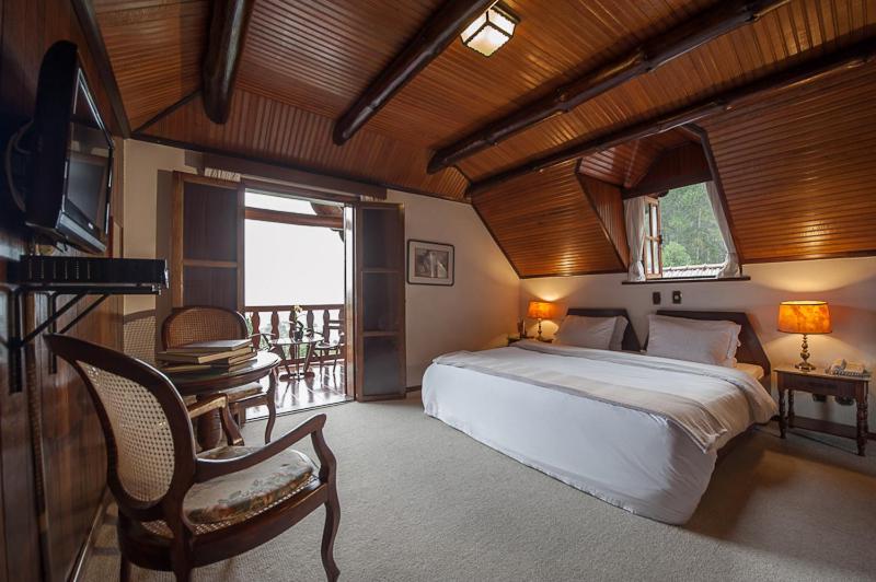 Quarto de casal com decoração elegante e rústica em Teresópolis