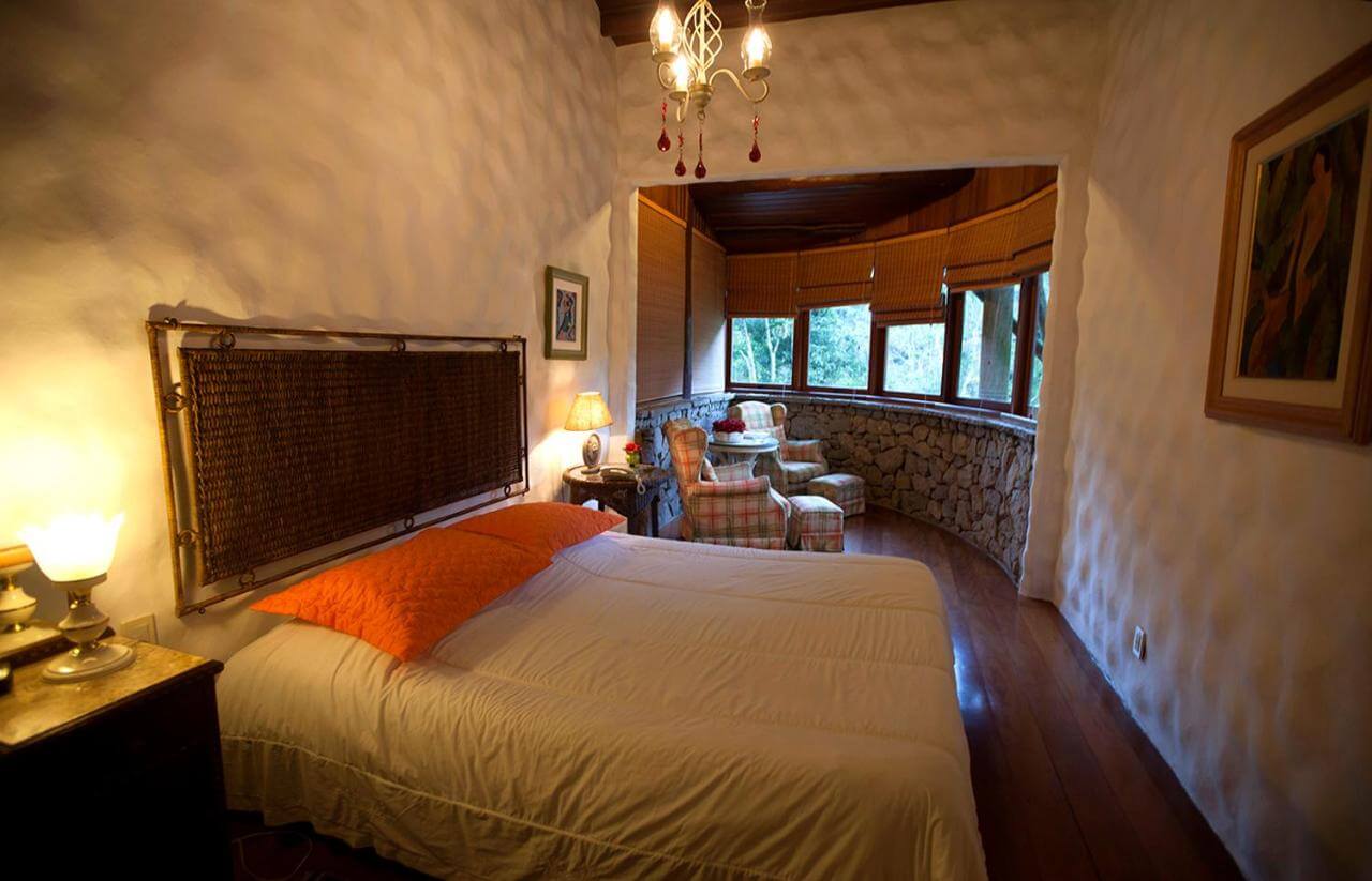 Quarto de casal com decoração rústica e elegante em acomodação em Teresópolis