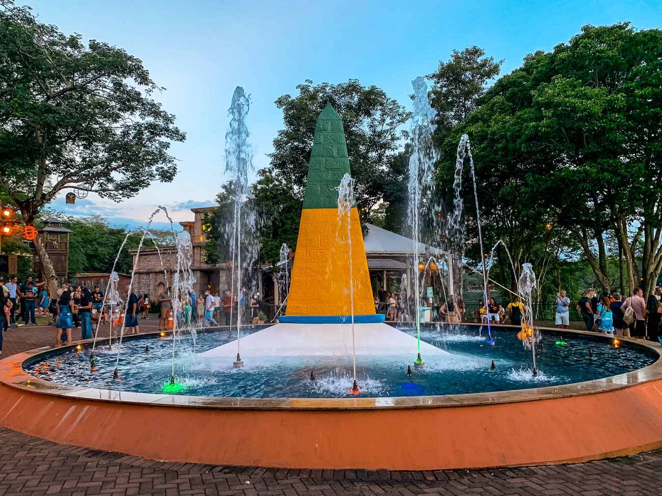 Obelisco em verde, amarelo, azul e branco em uma fonte no Marco das Três Fronteiras