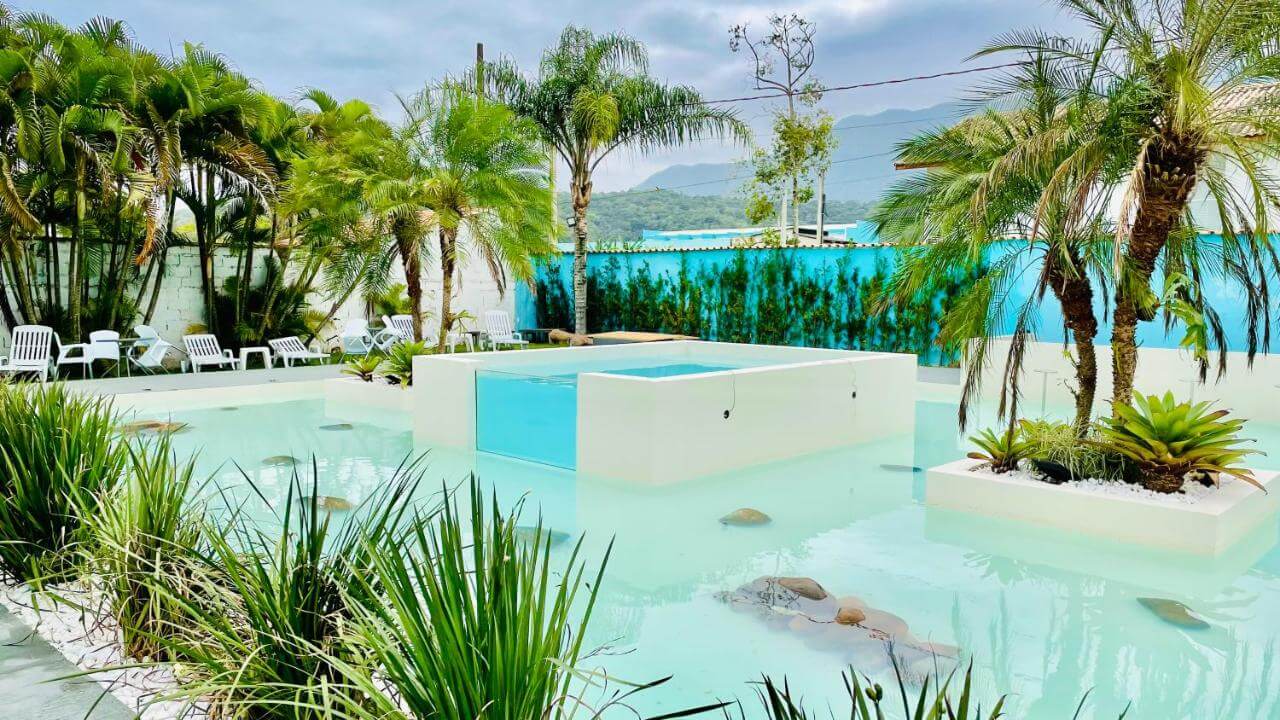Piscina com um paisagismo muito bonito em pousada em Caraguatatuba