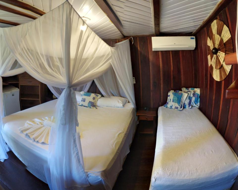 Quarto com cama de casal e de solteiro em pousada em Itacaré