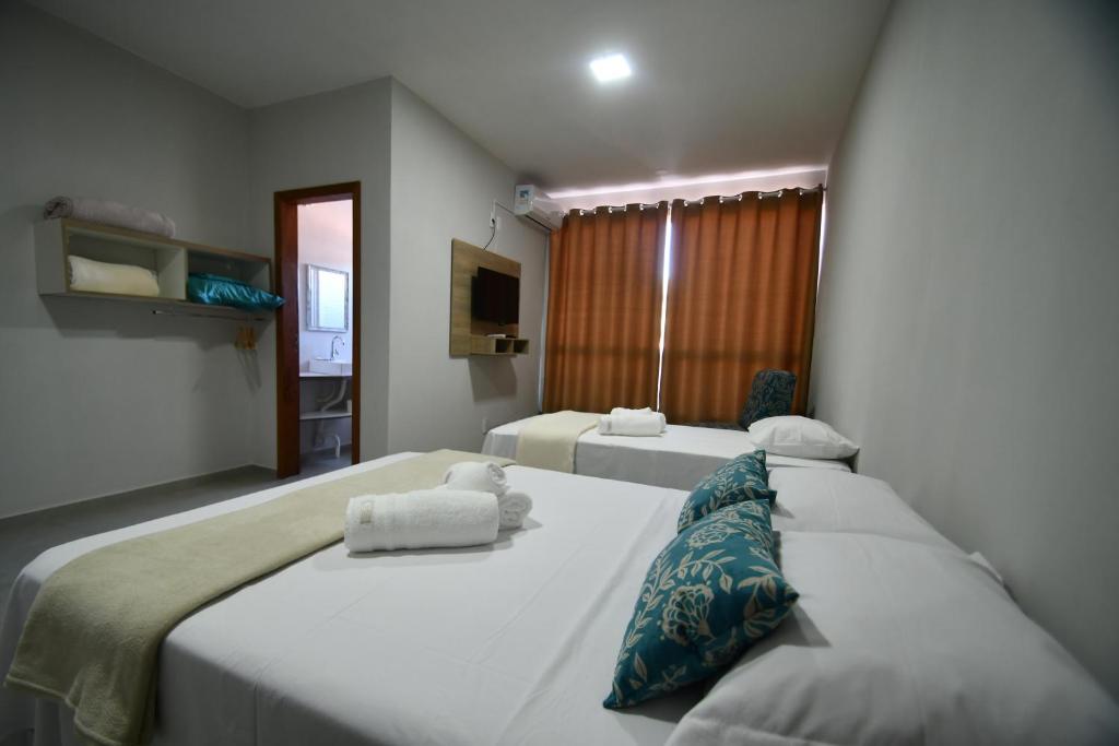 Quarto com camas de casal e solteiro em pousada em Laguna