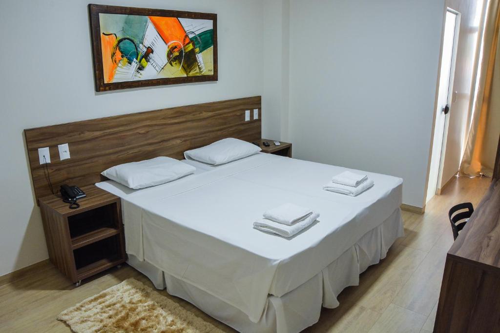 Cama de casal em quarto bem decorado no Mac Hotel