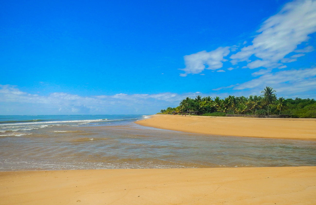 Praia de Guaiu com areia amarelada e mar tranquilo