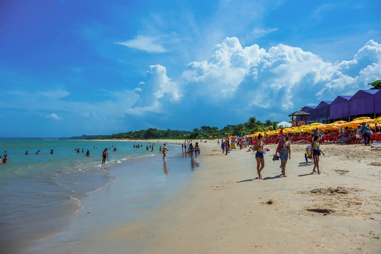 Pessoas caminhando na Praia de Taperapua