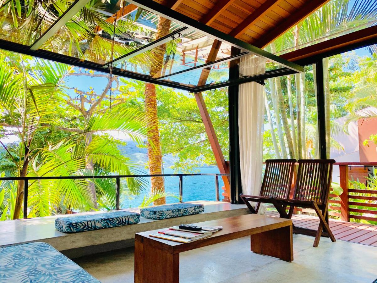 Lounge com vista para árvores e mar ao fundo 