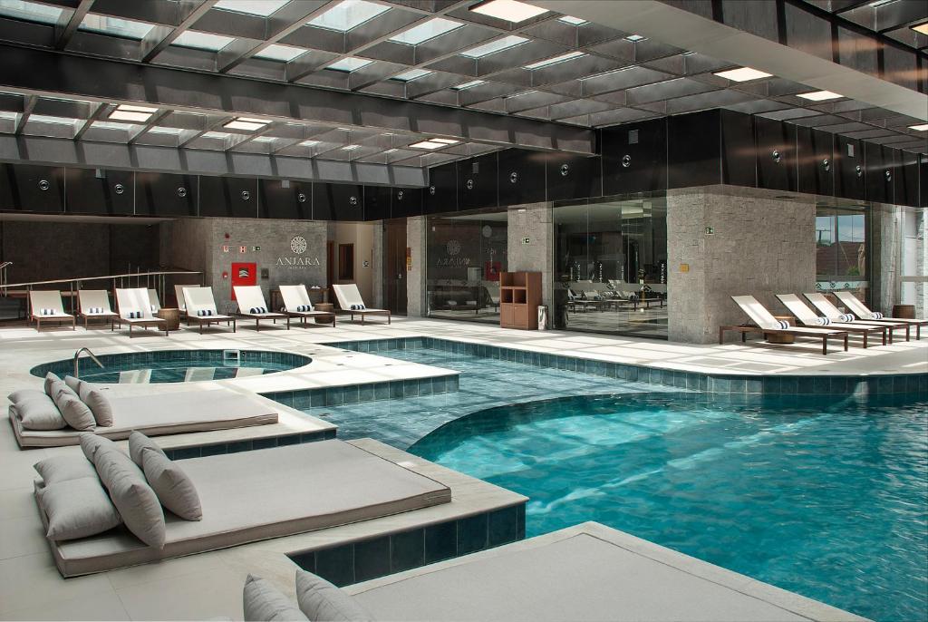 Piscina em área coberta com espreguiçadeiras