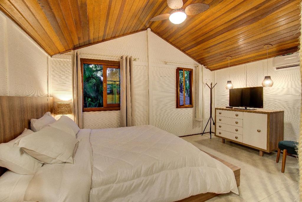 Quarto de casal com decoração rústica elegante em chalé na Ilha do Mel