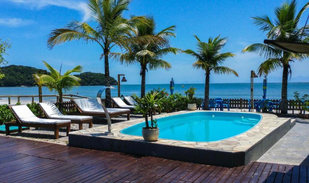 Piscina em deck de madeira ao ar livre com vista para o mar na Ilha do Mel
