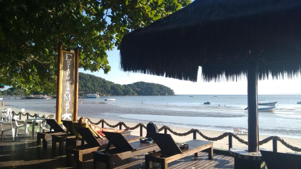 Deck de madeira com espreguiçadeiras à beira mar em pousada na Ilha do Mel