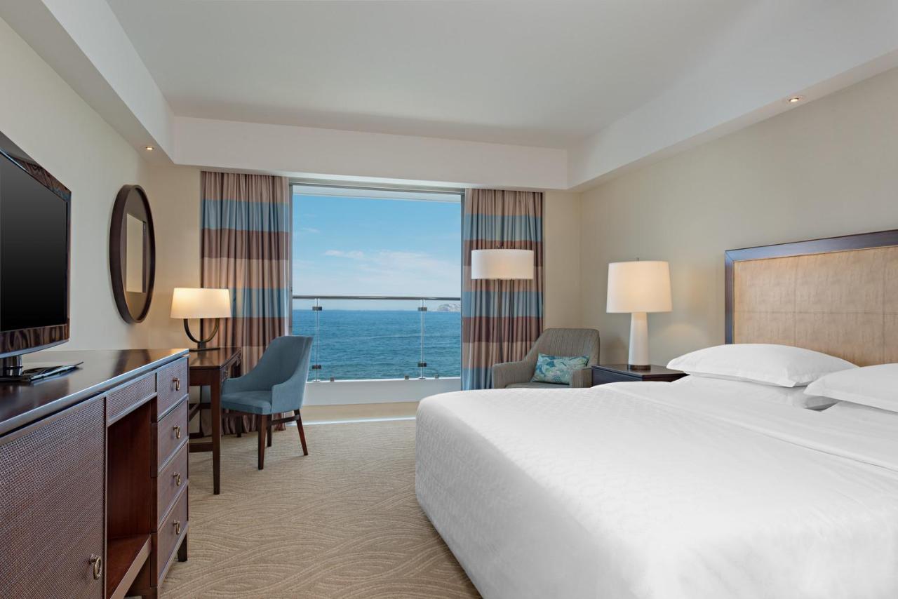 Quarto de casal luxuoso e ao fundo sacada com vista para o mar