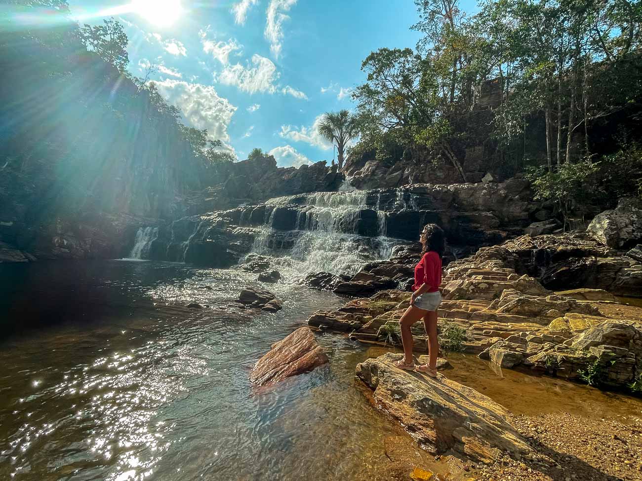 Mulher observando queda d'água da Cachoeira do Coqueiro