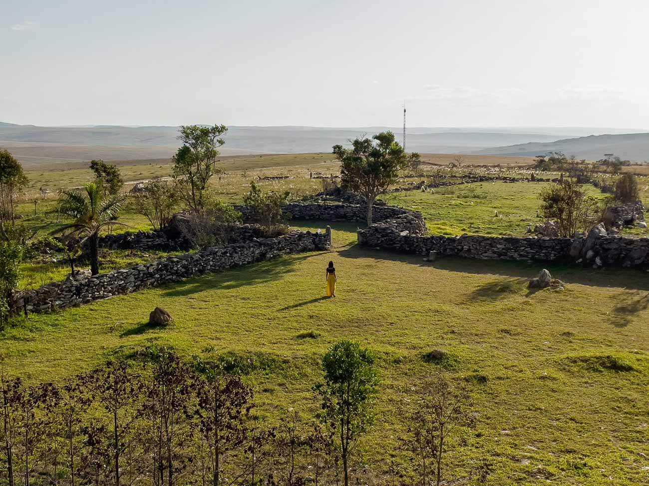 Mulher caminhando em área gramada do Curral de Pedras na Serra da Canastra